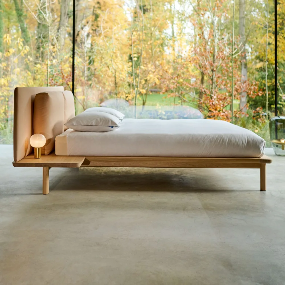 Auping Noble Solid Oak bed van massief eiken in een slaapkamer met raam over de volle breedte